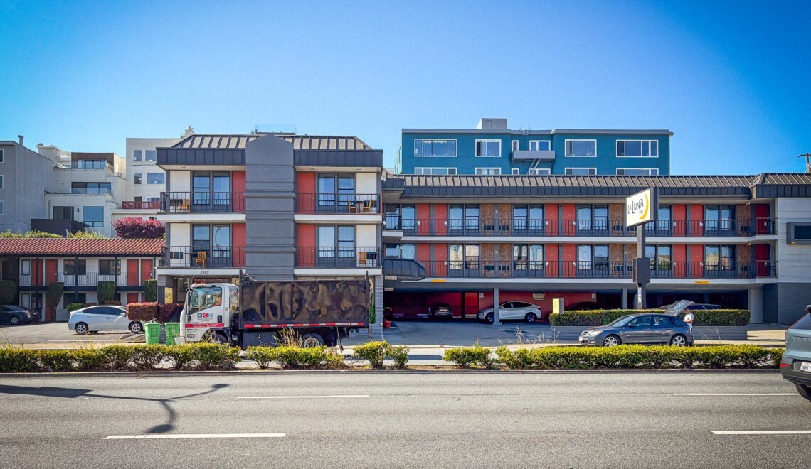 Street-level view of La Luna Inn in San Francisco's Marina District, showing the multi-story motel exterior with red accents and the property sign visible on the right.